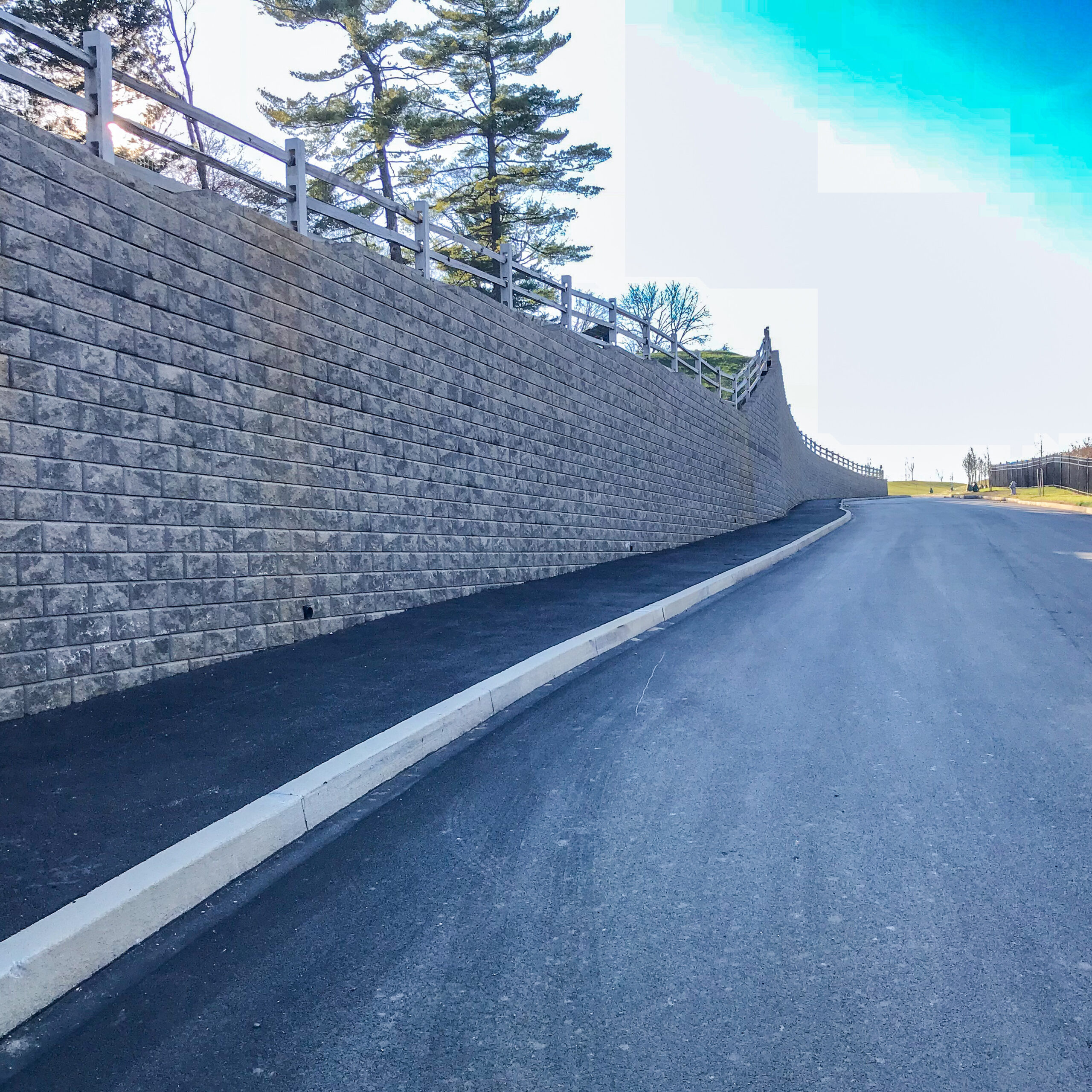 Large segmental retaining wall along a community roadway evaluated for long-term infrastructure performance.