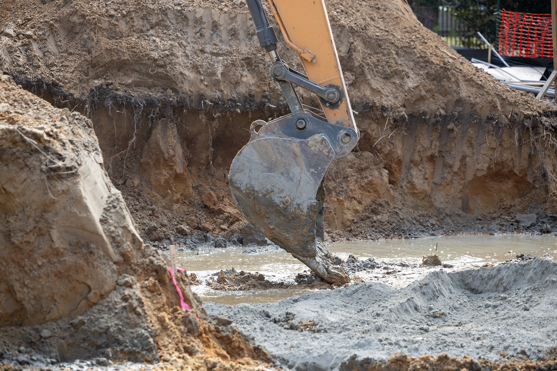 Excavator digging for geotechnical engineering in Delaware to evaluate coastal soils and subsurface conditions