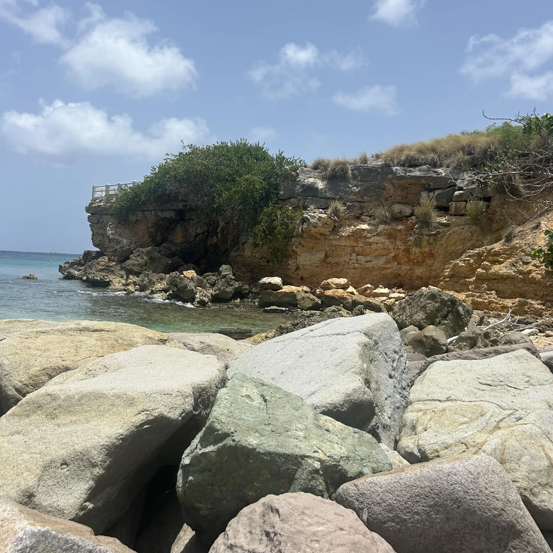 Caribbean shoreline and offshore breakwaters near eroding limestone cliff