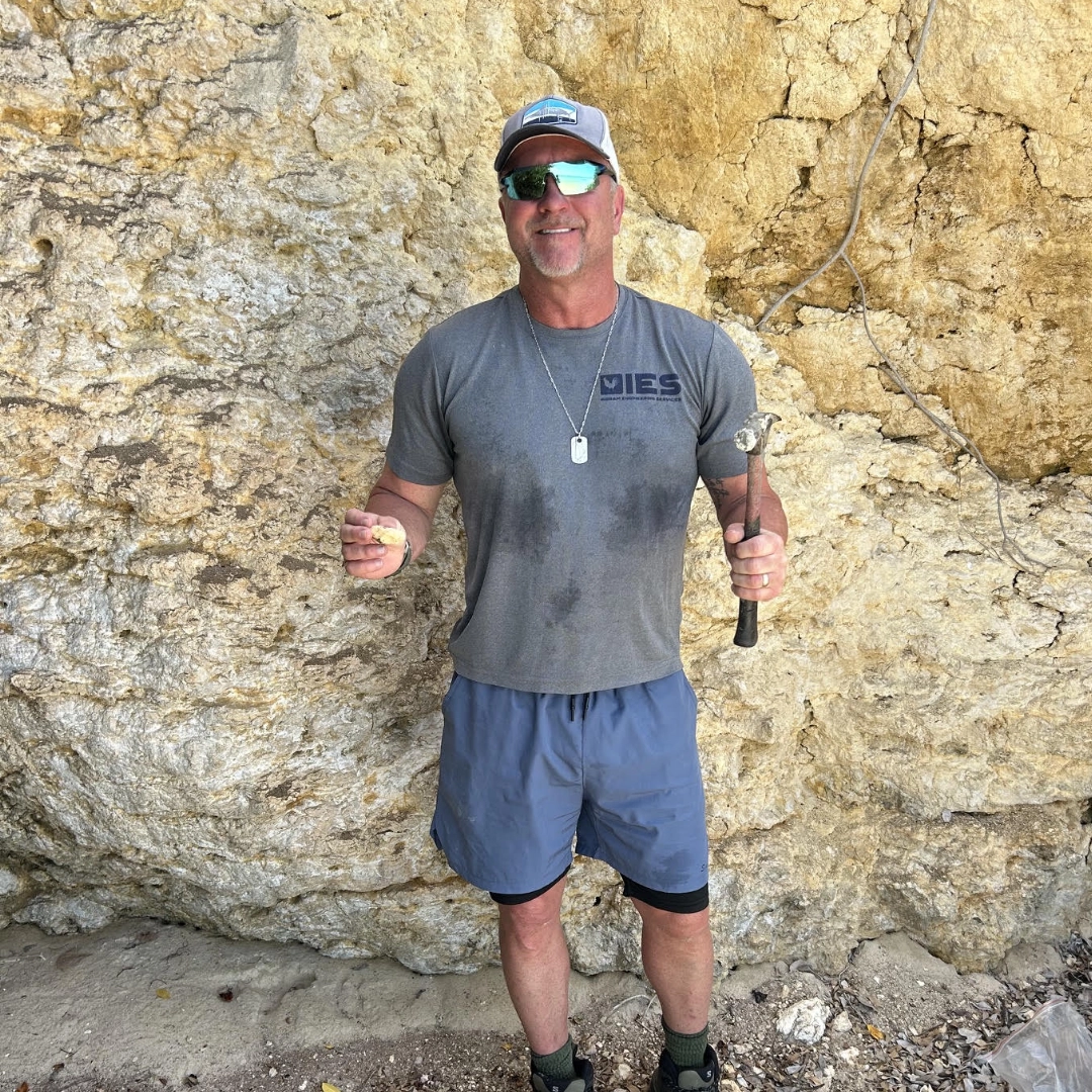 Chadd Ingram, P.E. inspecting eroded limestone cliff with hammer and rock sample at Caribbean resort