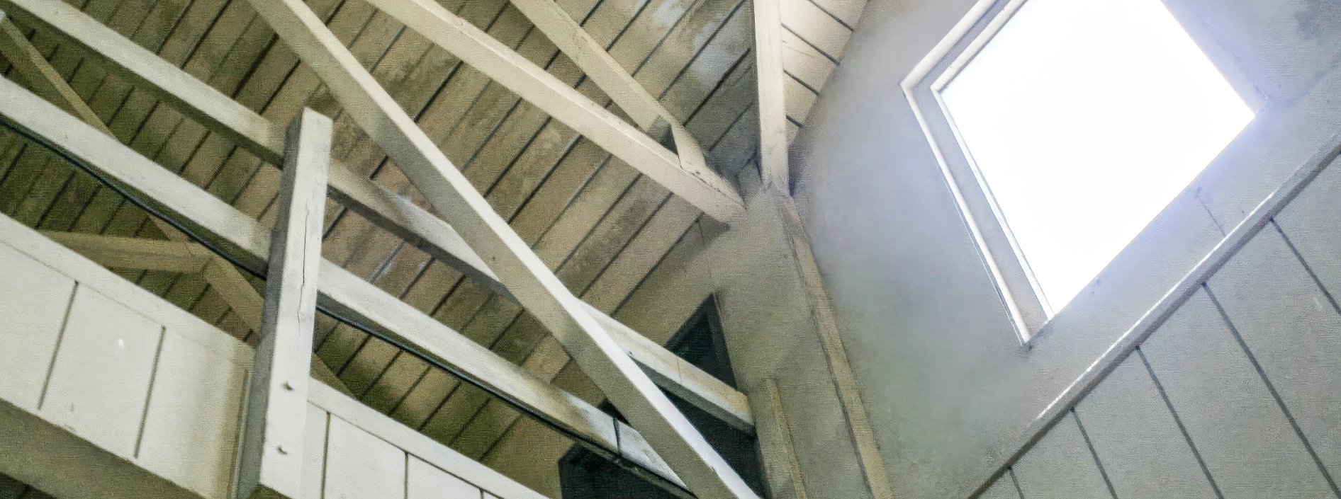 Roof trusses viewed from inside a structure during a structural engineering evaluation