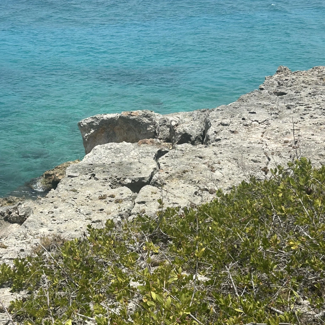 Villa foundation overhanging eroded cliff edge above the shoreline