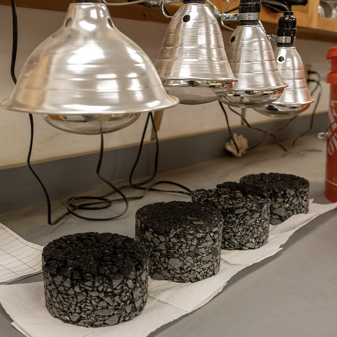 Asphalt pavement samples beneath heat lamps at Ingram Engineering’s construction materials testing laboratory in West Chester, PA.